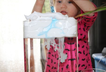 A little girl doing fun science experiment for kids. 