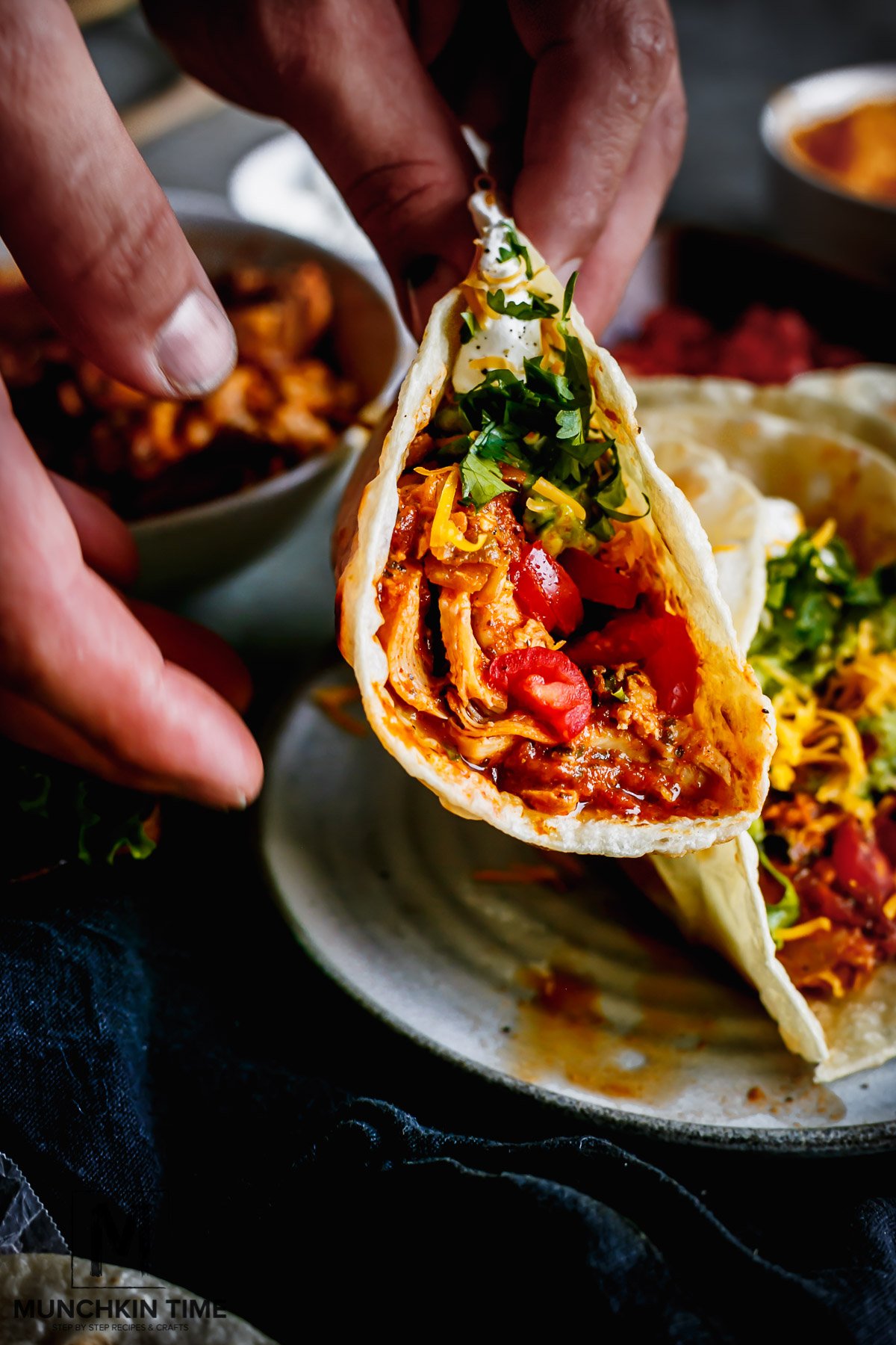 Two hands carefully holding warm Chicken Tacos, moving slowly so the shredded chicken juice doesn't escape from the tortilla.