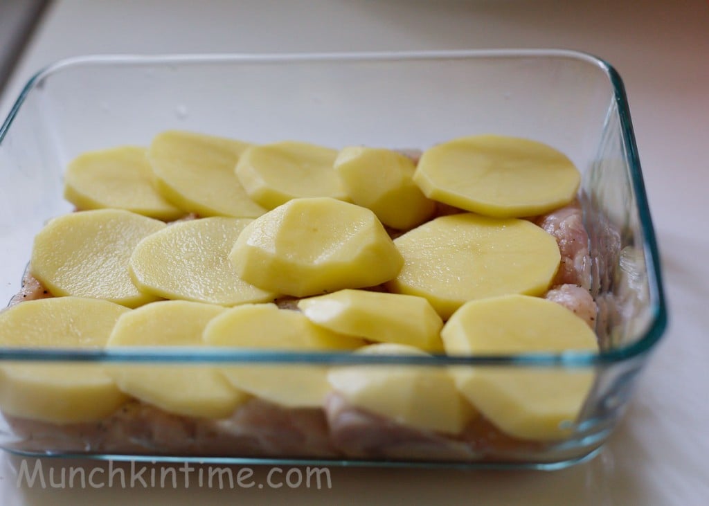 Sliced potatoes added to the chicken casserole.