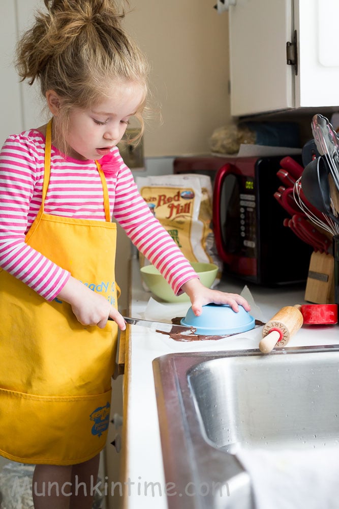 A little girl baking a cake. 
