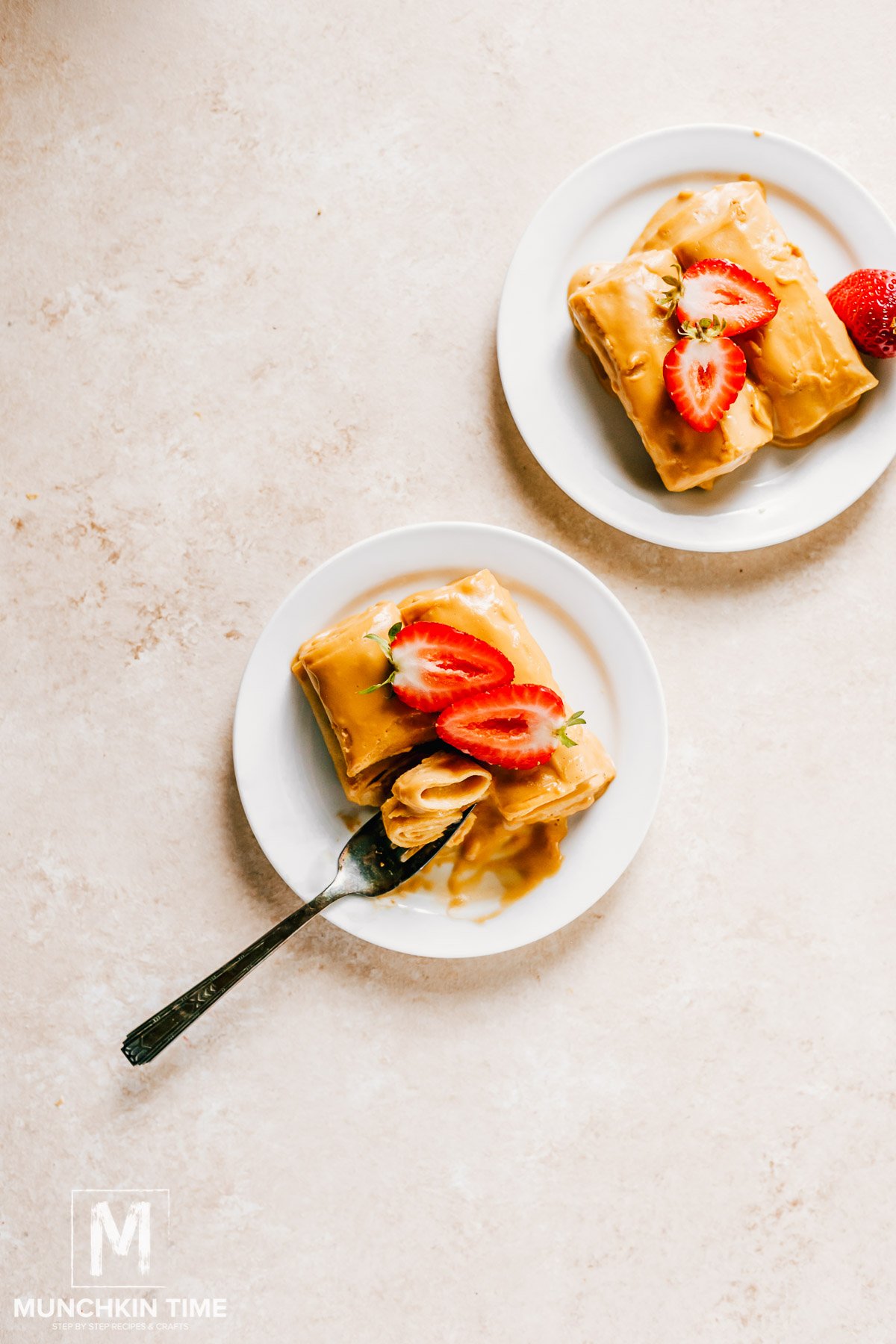 A picture of easy crepe recipe filled with cream and garnished with sliced strawberries.