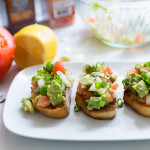 A plate with tomato bruschetta and ingredients on the side.
