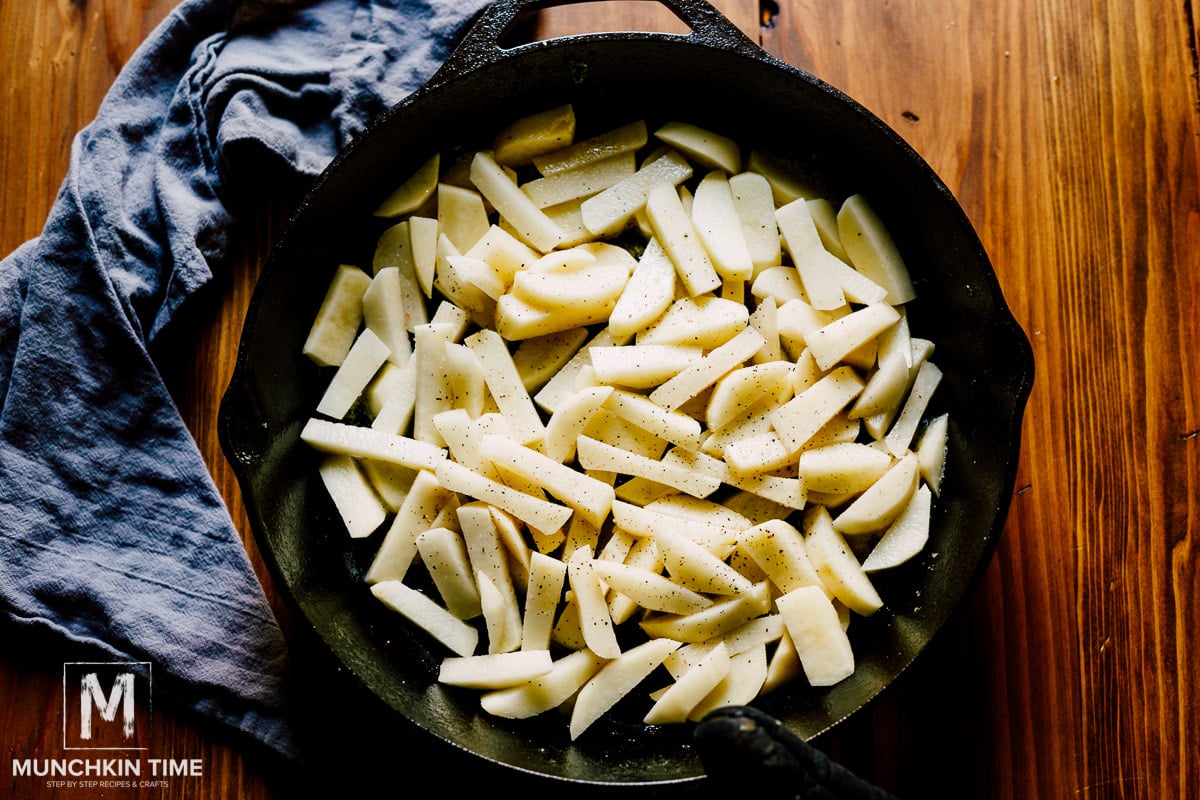 Sliced potato inside the skillet ready to be cooked.