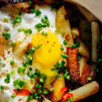 Potato Hash with Eggs garnished with chives and black pepper.
