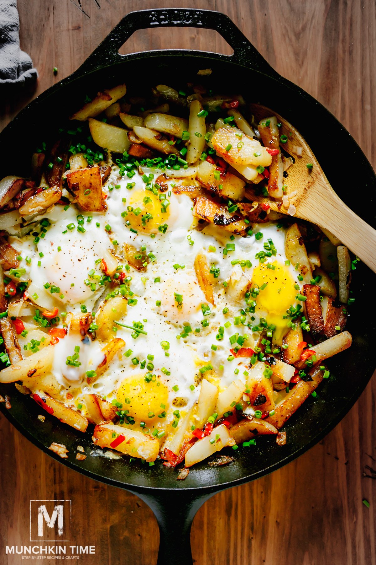 Hash Brown Potatoes inside the cast iron skillet, garnished with chives and black pepper.