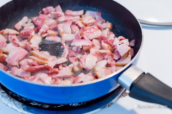 Bacon cooking in the skillet.