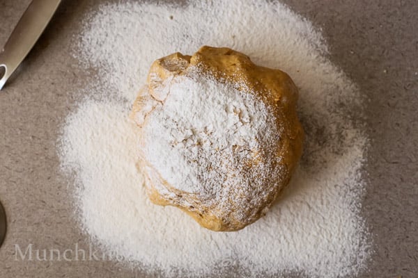 Dough ball on a table with flour sprinkled all over it. 