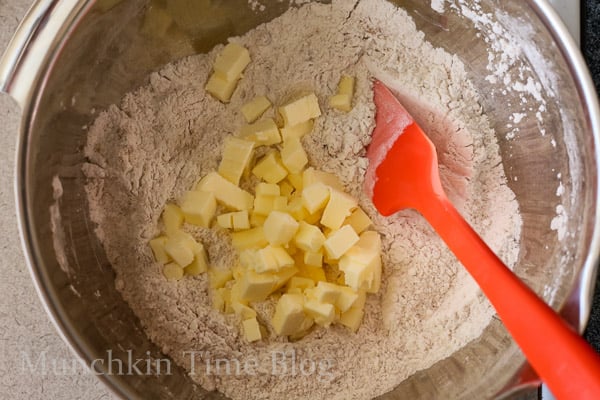 Butter added into the dry ingredients inside mixing bowl.