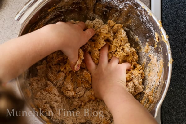 Hands kneading the pumpkin scones dough. 