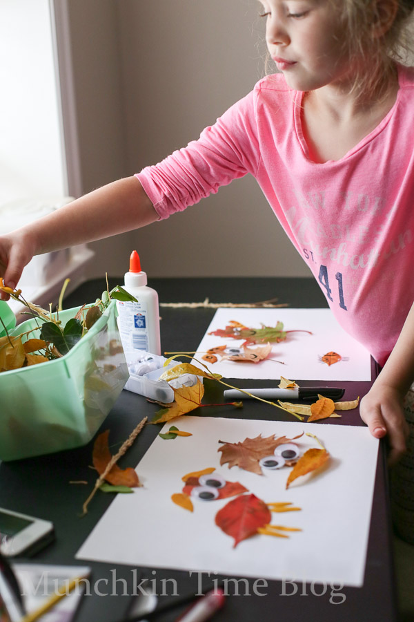 A girl almost done with her fall leaf craft. 