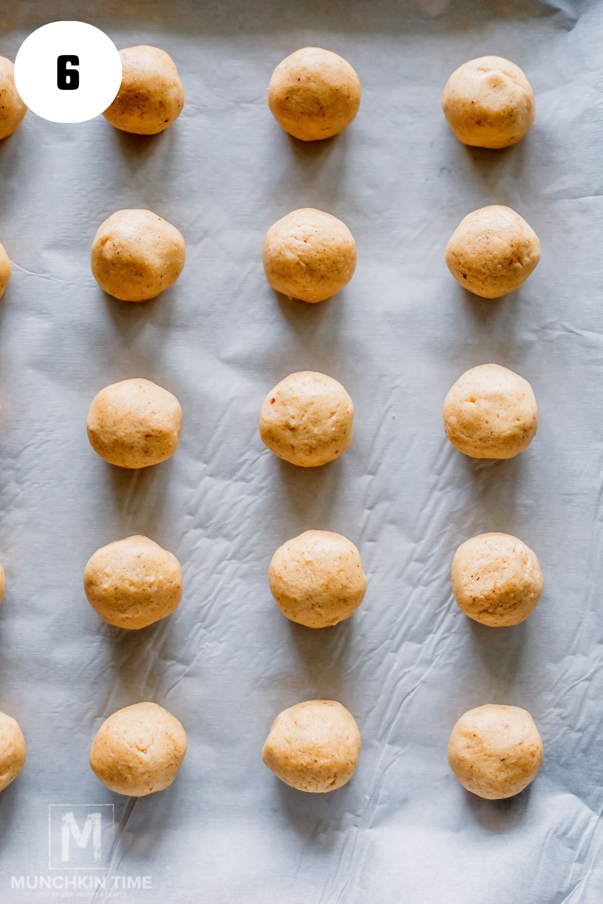 perfectly formed cookie dough balls on a parchment paper.
