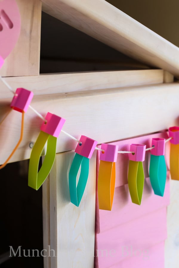 Christmas Paper Lights made out of construction paper, hanging on a play house.