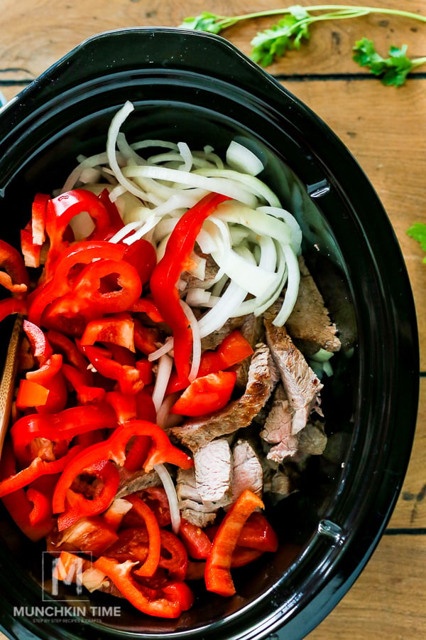 Steak plus all ingredients inside the slow cooker ready for cooking. 