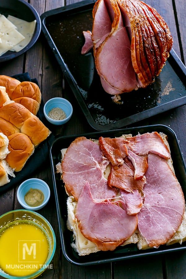 Ham sliced and placed with cheese over buns. 