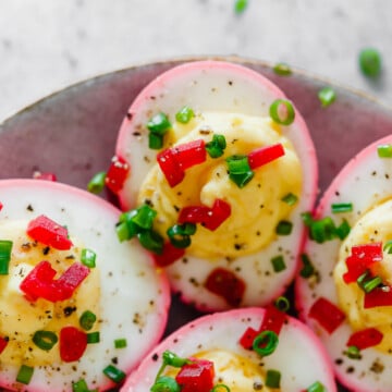 beet dyed deviled eggs with egg yolk filling and garnished with finely diced beets and chives.