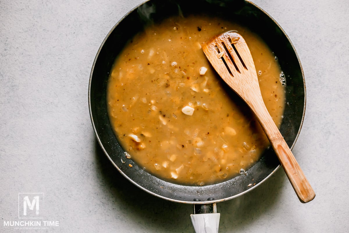 A skillet with Chicken Piccata sauce. 