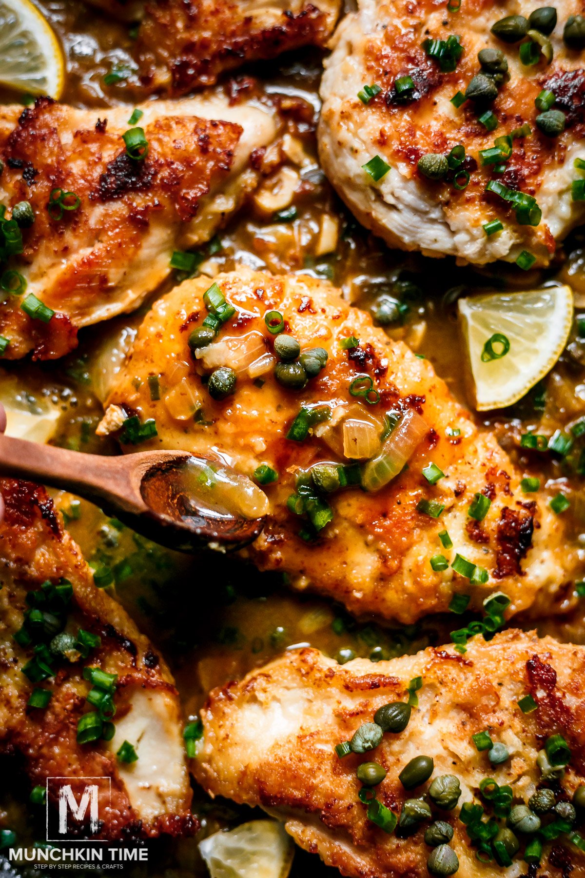 A close up of Chicken Piccata recipe, a sauce pouring over chicken breast.