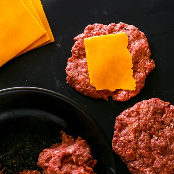 ground beef shaped into patties with cheese on top