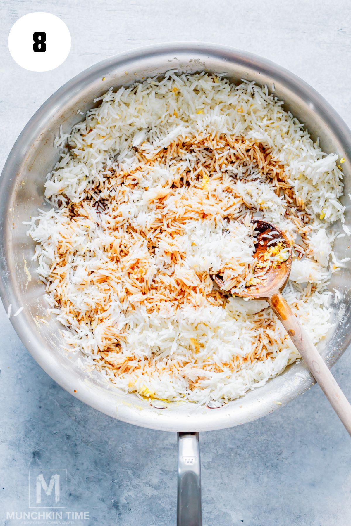 Pouring soy sauce over rice for a flavorful fried rice recipe.