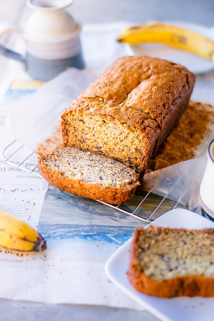 Sliced banana bread on a cooling rack plus one slice on a white plate. 