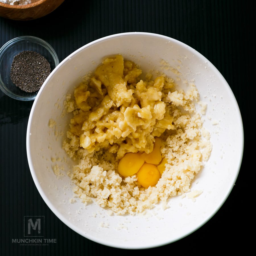 Mashed bananas added to the bowl with raw eggs to make banana bread batter.