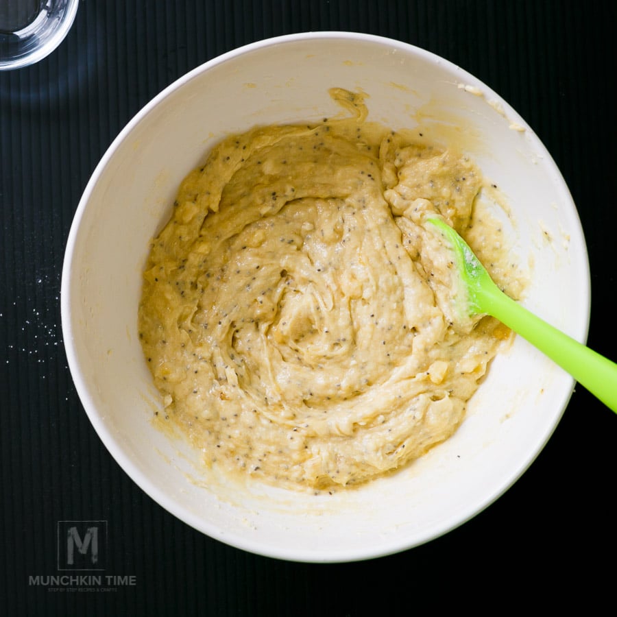 Batter inside white bowl with a green spatula inside the batter. 