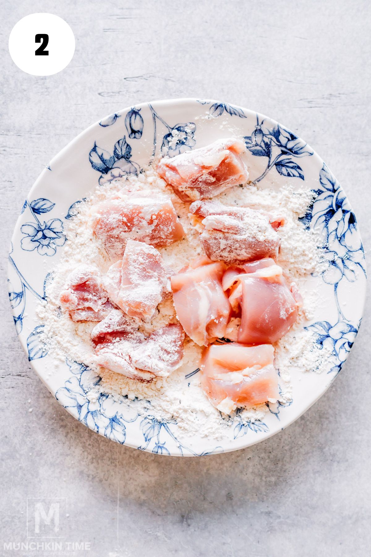 Raw chicken thighs being patted dry before seasoning for Spanish chicken and rice