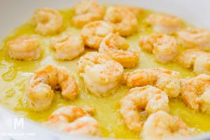 skillet with shrimp cooking in oil