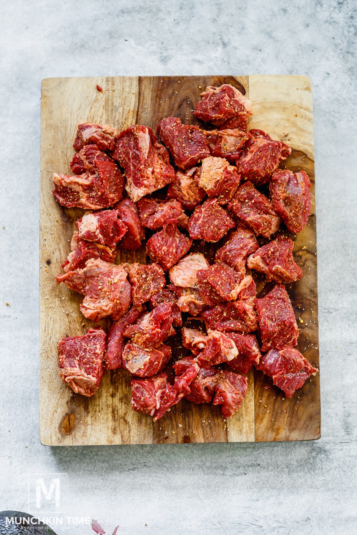 Pot roast beef cut into big chunks on a cutting board.