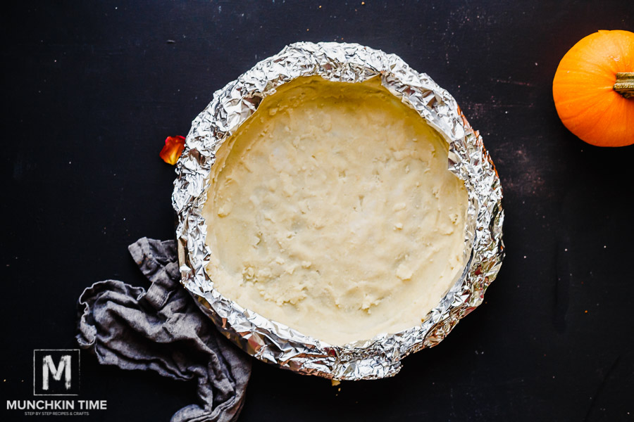 Pumpkin pie crust covered with foil paper. 