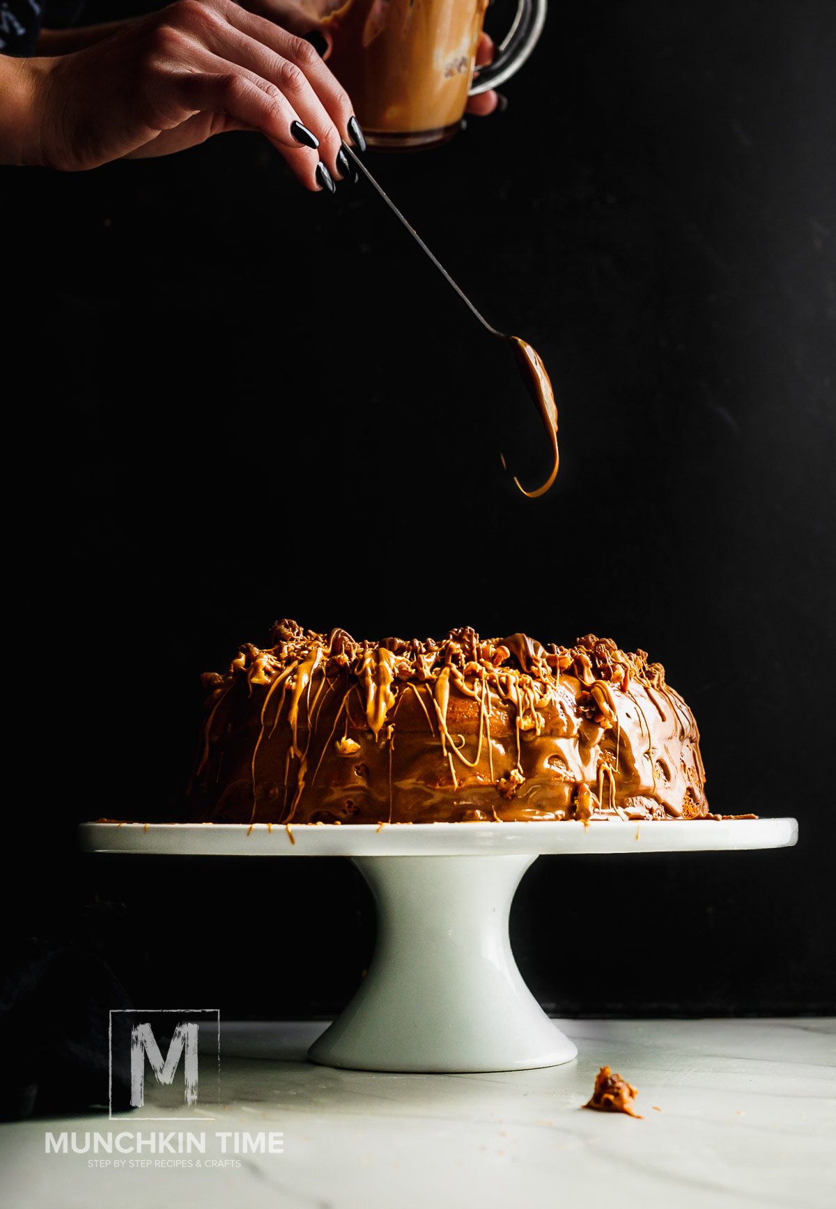 Munchkin Time's Candied & Moist Vanilla Bundt Cake on a white candle stand. A side shot of a vanilla bundt cake, drizzle of a cream over easy vanilla bundt cake, candid walnuts and cream.