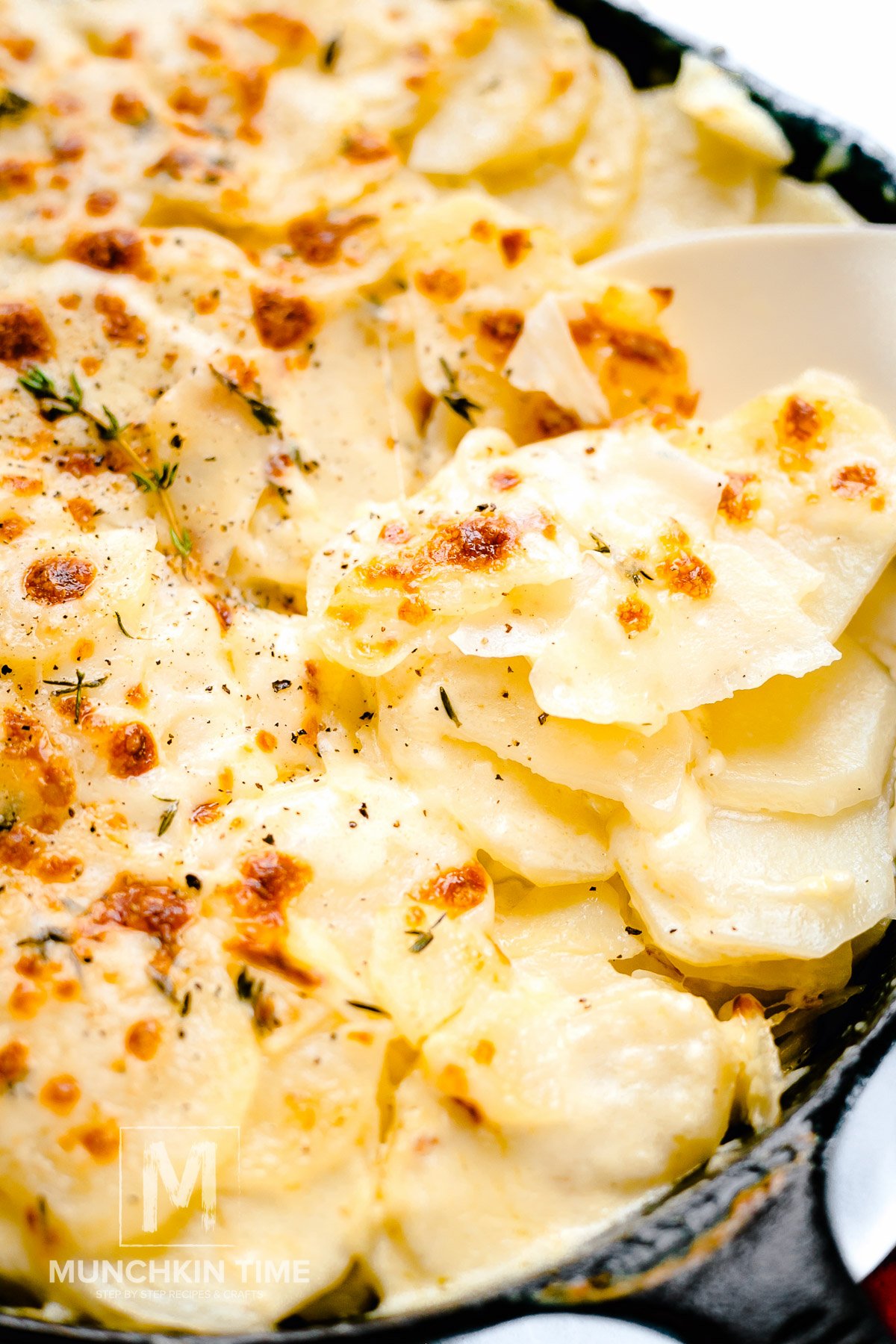 Munchkin Time's Cheesy Scalloped Potatoes in cast iron skillet.