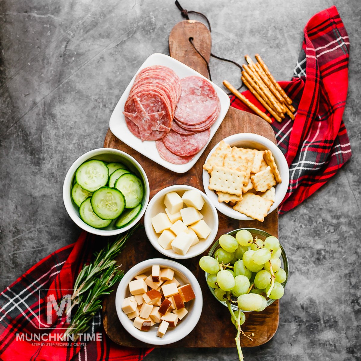 Ingredients to make cheese platter on a wooden board. 