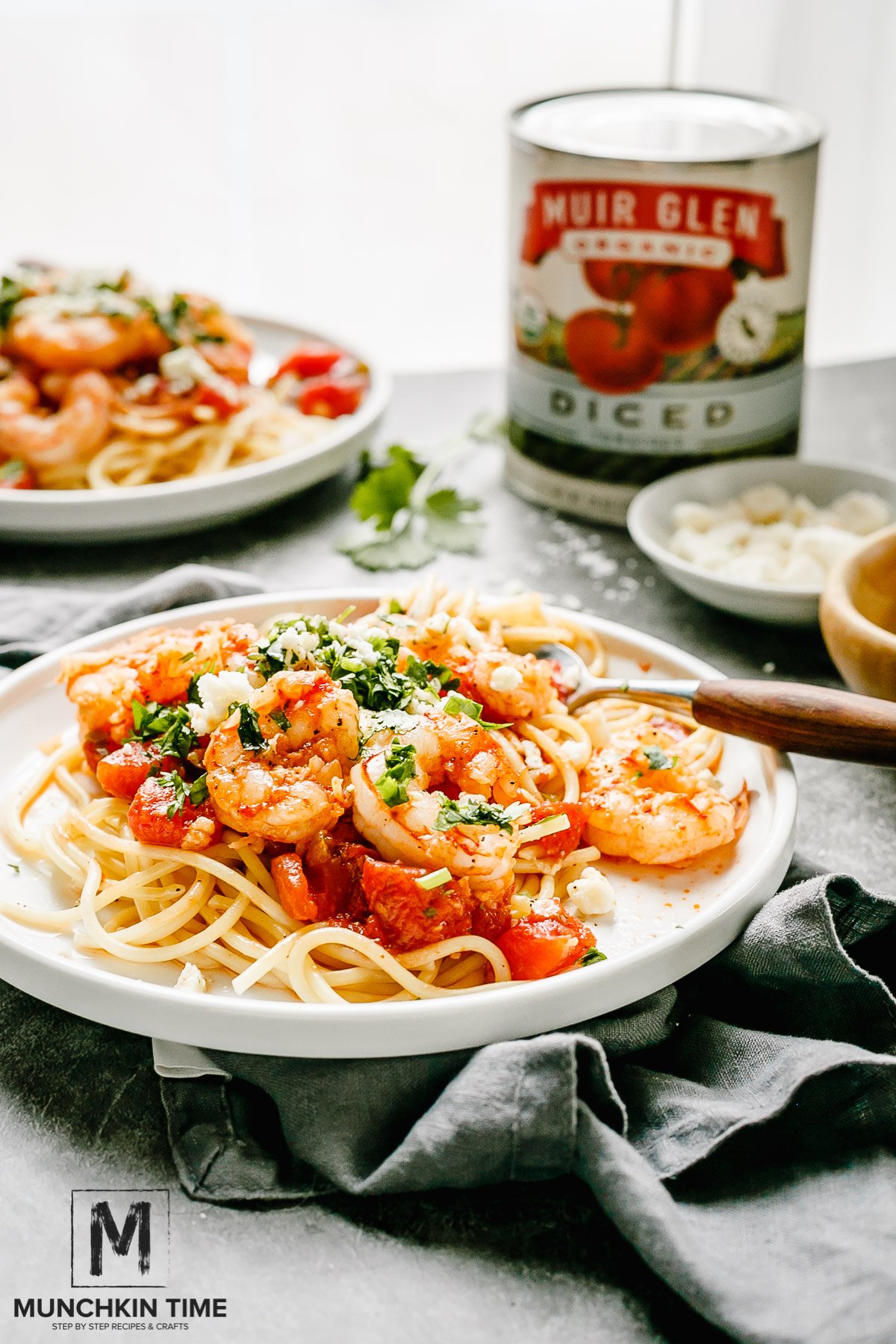 Italian Shrimp Tomato Pasta with feta cheese and cilantro greens on a plate with a fork.