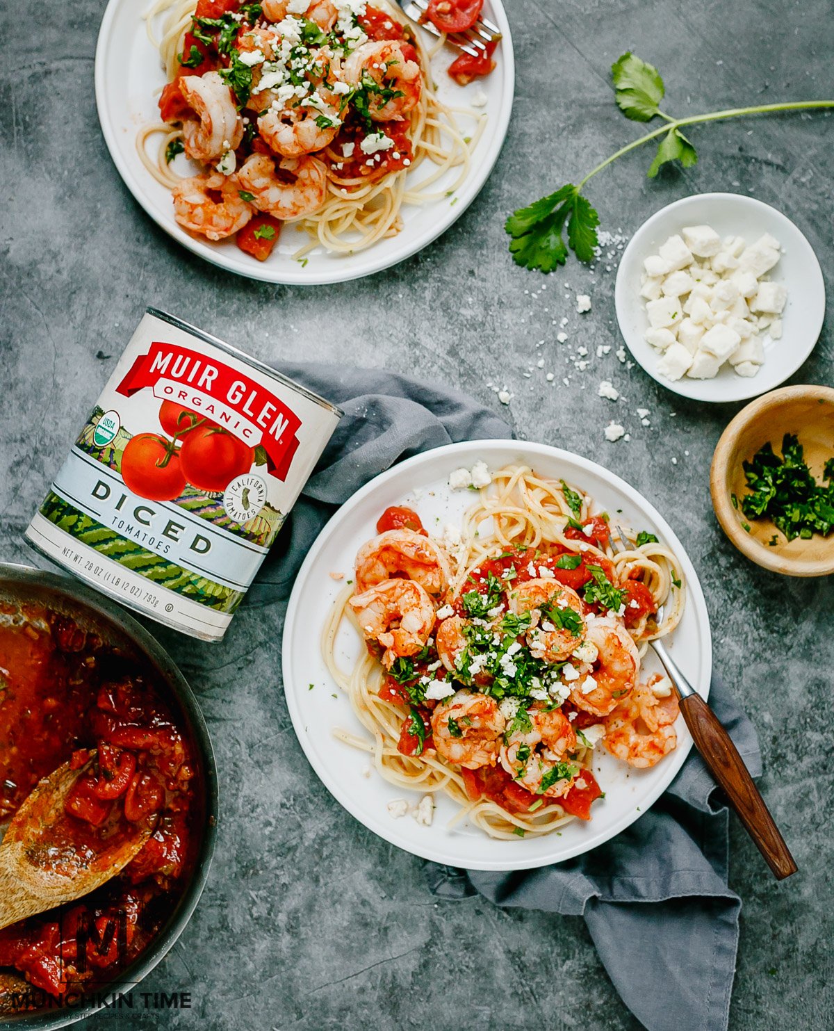 Over the top view of finally shot of Shrimp Tomato Pasta in 2 plates with tomato sauce and feta on the side.