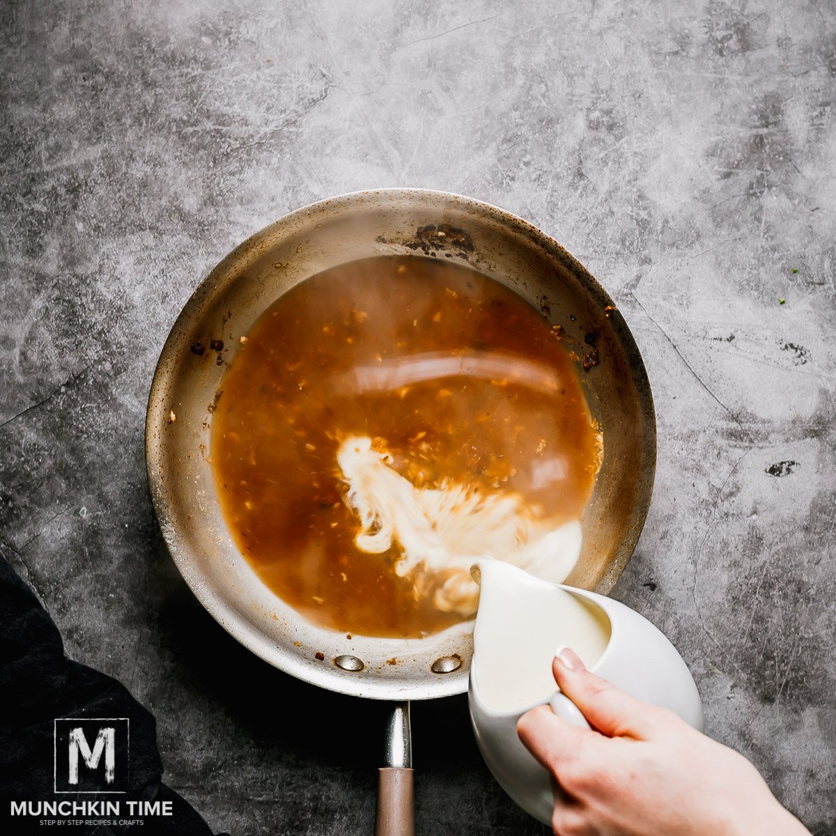 cream being poured in the skillet to make white sauce.