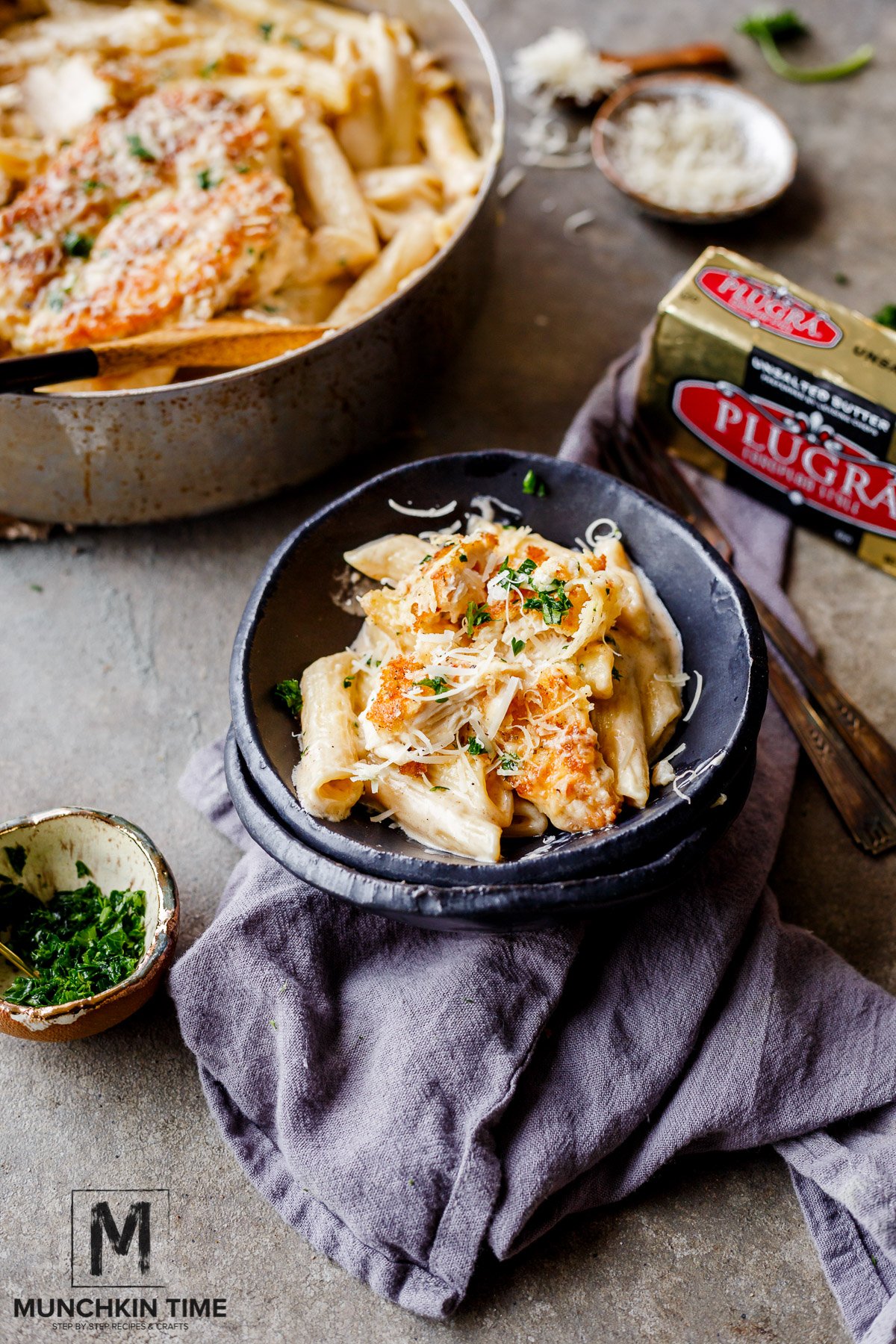 Oven Baked Chicken Pasta in Buttery White Sauce inside the place plate with a grey napkin underneath. 