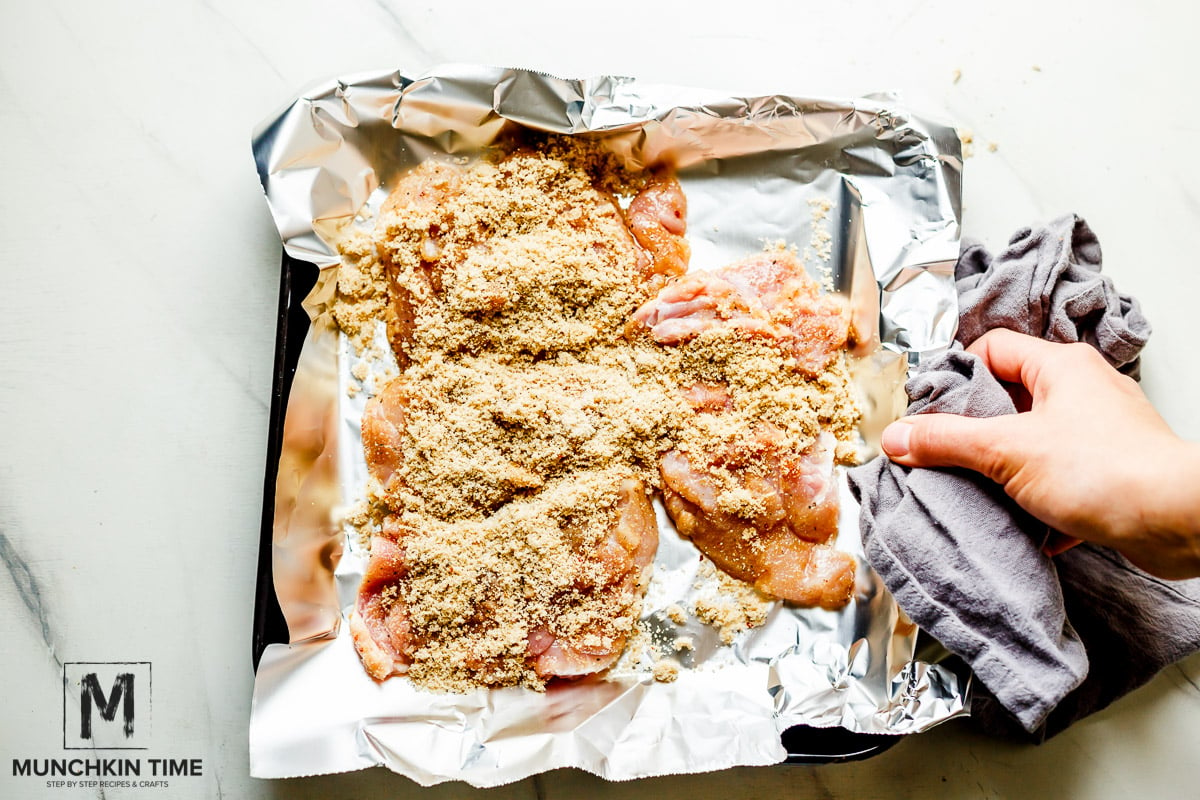 chicken thighs seasoned and placed on a baking sheet with foil paper