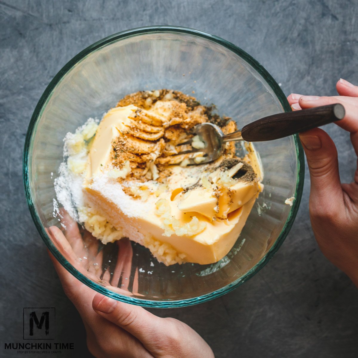 Butter with spices inside the bowl mixed with a fork.