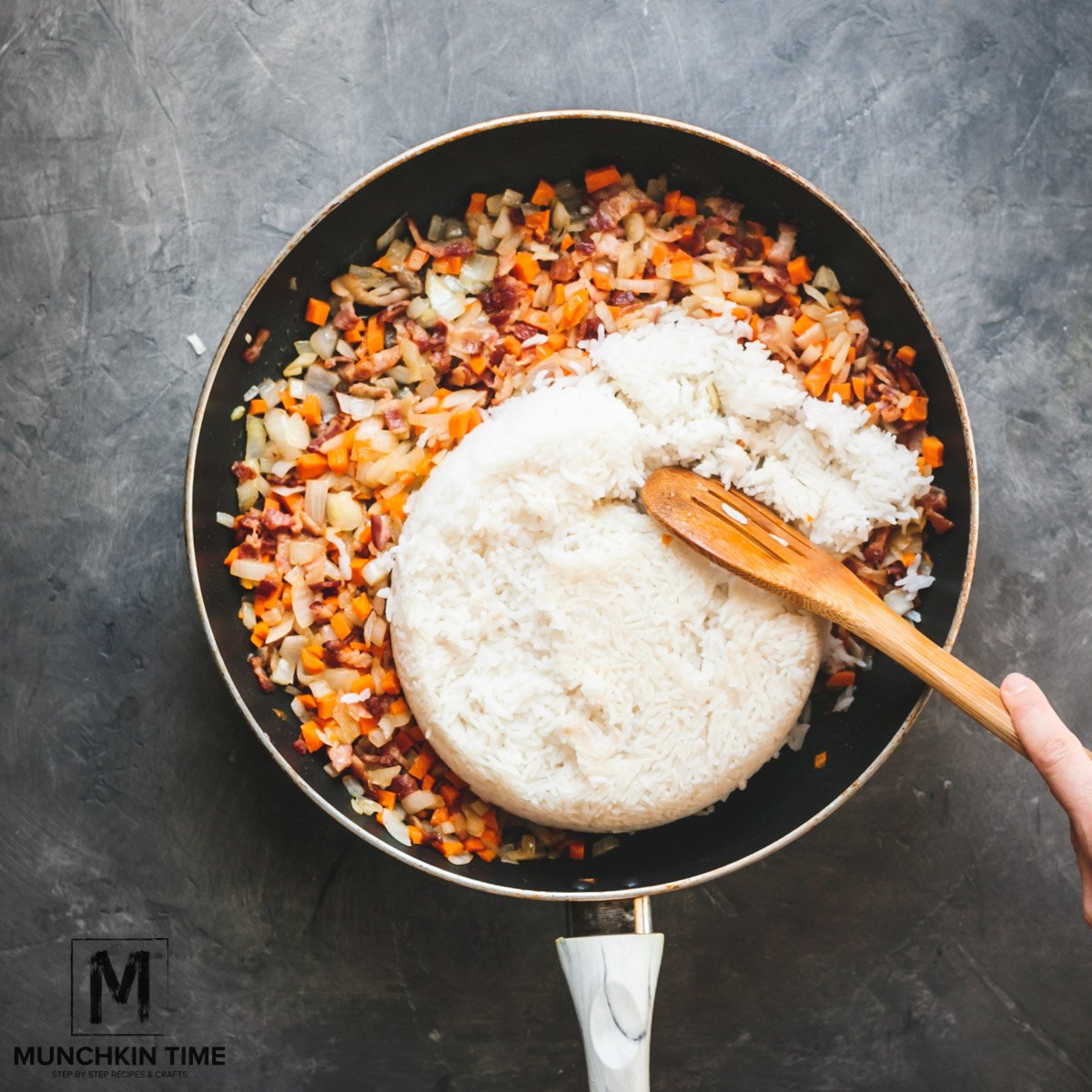 Cooked rice added into skillet with bacon and rice.