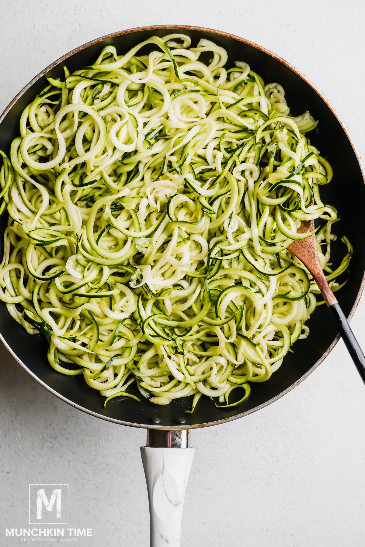 Zucchini noddles cooking in the skillet.