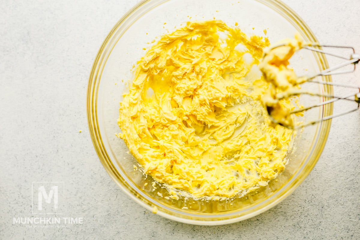 Butter, sugar and eggs whisk inside the bowl.