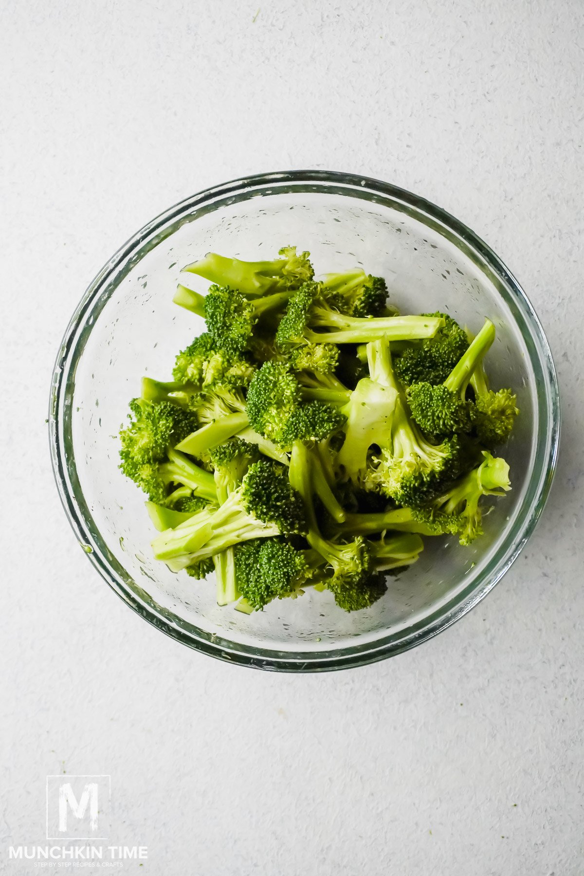 Broccoli mixed with salt, pepper & avocado oil, ready for roasting. 