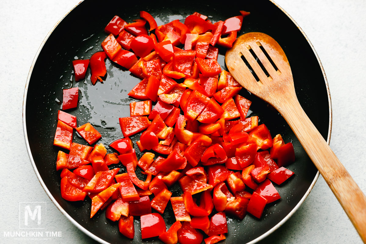 Oil and red bell pepper added to the big skillet.