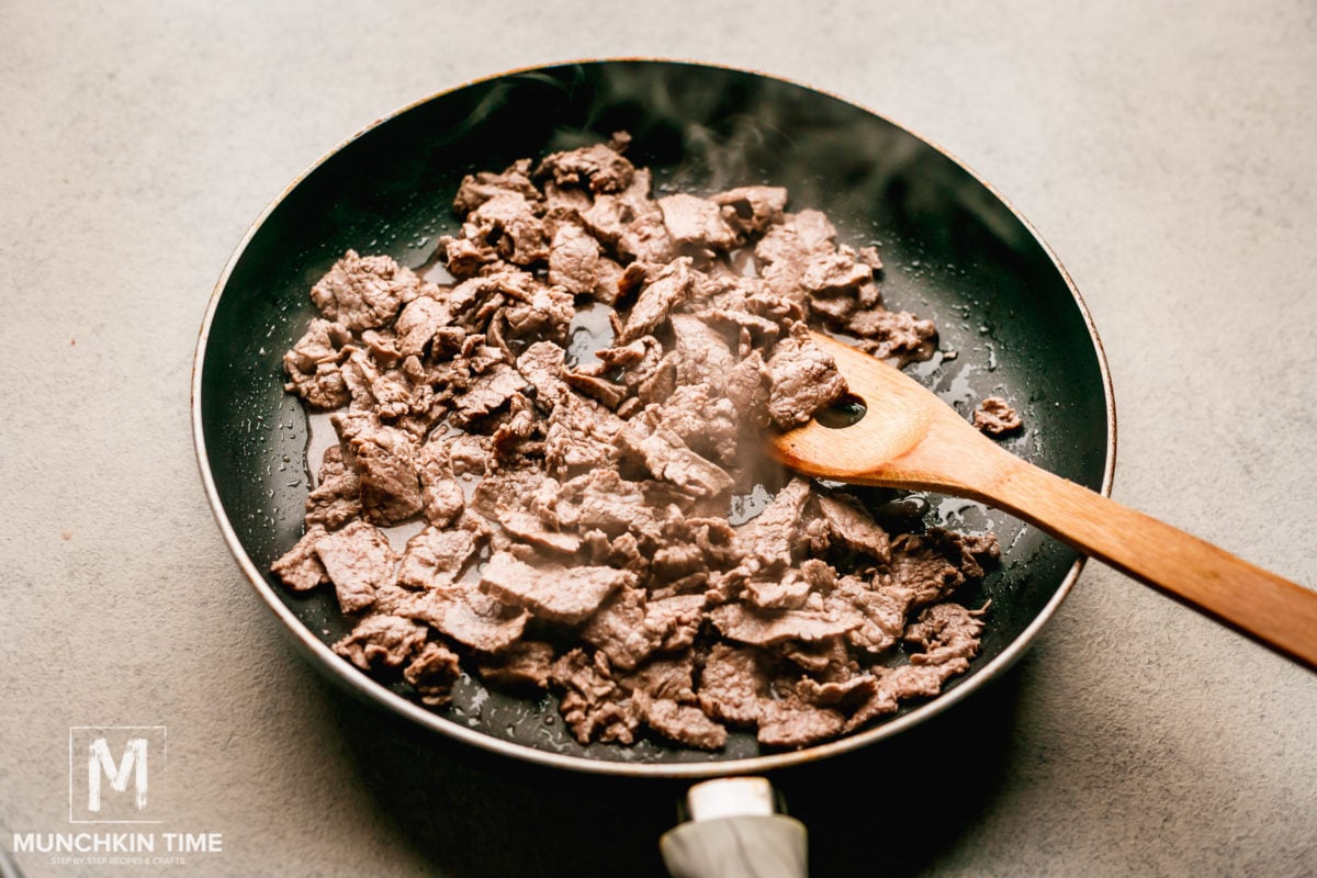 Flank steak inside the skillet cooking.