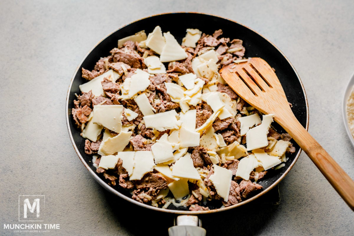 How to make beef chimichangas with cheese. Add cheese to the skillet with beef.