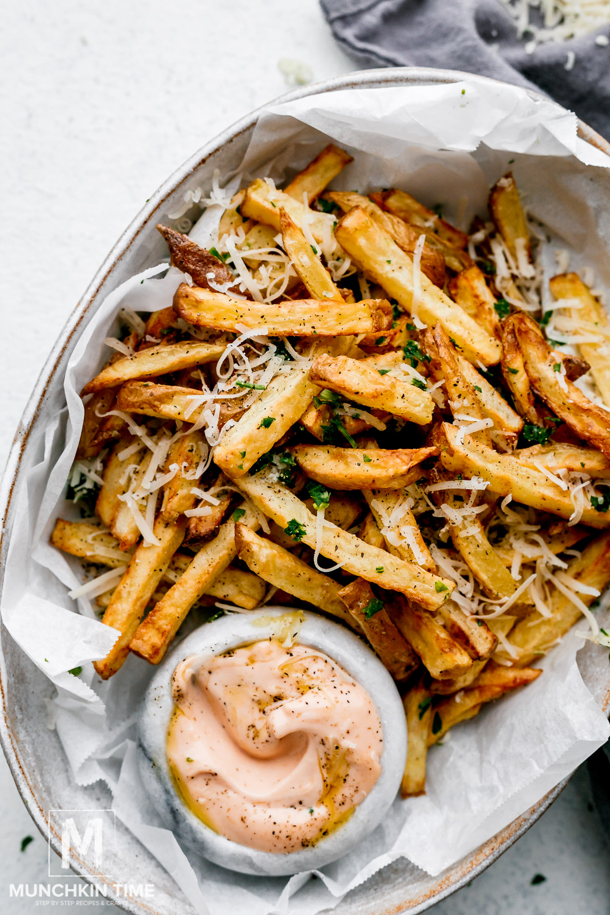 Air Fryer French Fries served with sriracha mayo, parsley and Parmesan cheese.