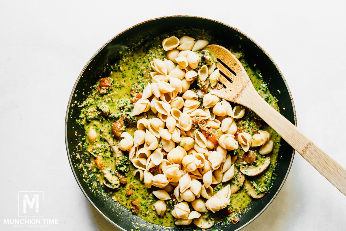 Pasta added to the pesto sauce with mushrooms.