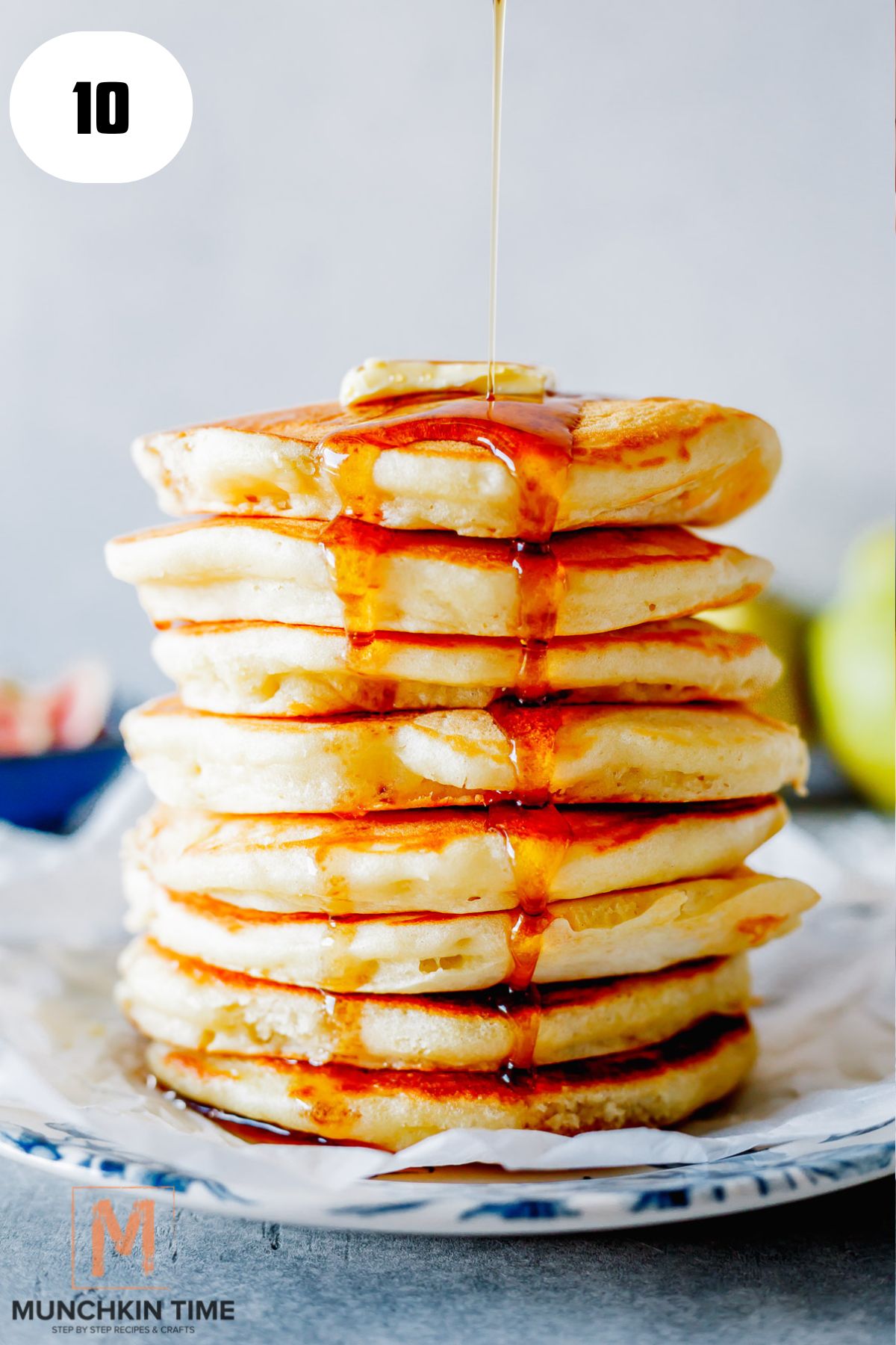 fluffy buttermilk pancakes and maple syrup being poured over the top.