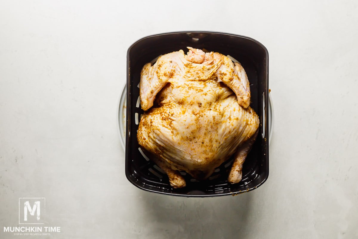 Whole chicken air fryer laying breast side down ready for cooking.